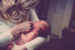 Mama hält ihr Neugeborenes im Arm