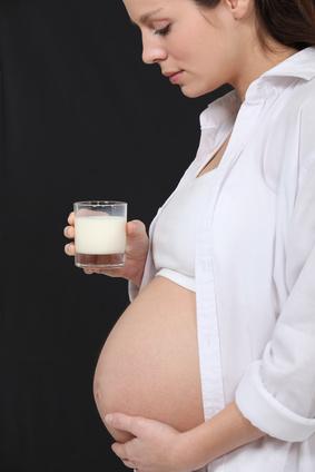 Schwangere mit Milchglas in der Hand