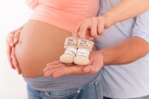Bei auffäligen Symptomen sollte dringend ein Arzt aufgesucht werden. Bild Babybauch mit Mama und Papa