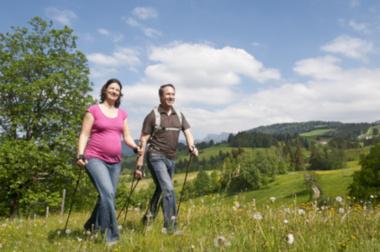 Schwangeres Paar beim Nordic Walking