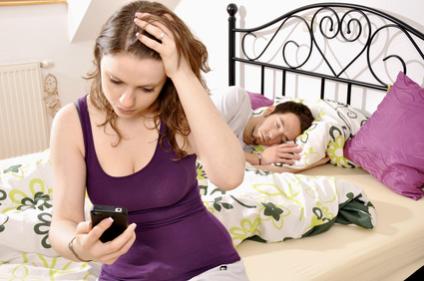 Frau checkt Handy von Partner