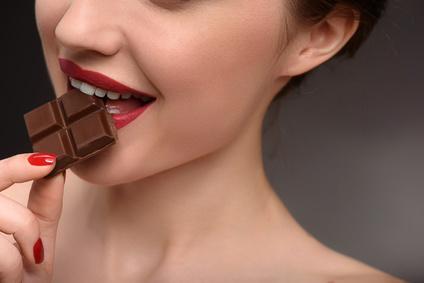 Schwangere Frau isst Schokolade