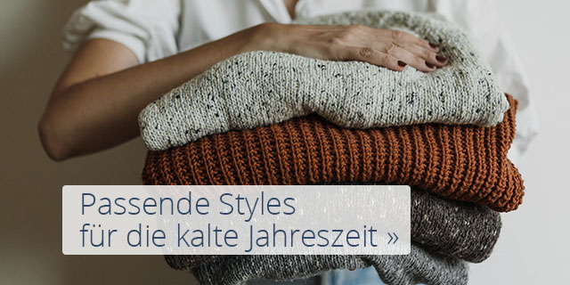 Frau hält Stapel Pullover mit der Aufschrift 