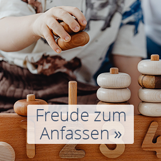Kind greift nach Spielzeug: Freude zum Anfassen