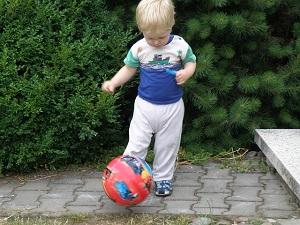 Ein Junge, welcher Ball spielt.