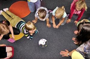 Kinder spielen in einem Spielkreis.