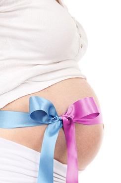 Eine gesunde Ernährung kann Schwangerschaftsstreifen positiv beeinflussen. Bild Schwangerschaftsbauch mit Schleife