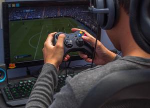 Bild Mann spielt FIFA an der Xbox